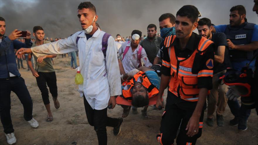 Paramédicos palestinos llevan a un manifestante que resultó herido por represión de las fuerzas israelíes en Gaza, 5 de octubre de 2018. (Foto: AFP)