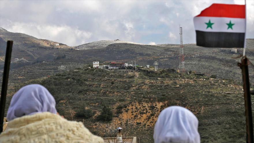 Mujeres residentes en Majdal Shams, en los altos del Golán en Siria, miran al otro lado de la frontera, 14 de febrero de 2019. (Foto: AFP)