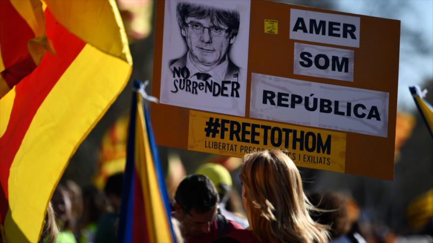 Independista catalana exhibe la cara del expresidente regional Carles Puigdemont en una protesta en Madrid (capital de España), 16 de marzo de 2019. (Foto: AFP)
