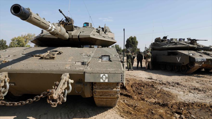 Soldados israelíes junto a los tanques estacionados a lo largo de la línea divisoria con la Franja de Gaza, 13 de noviembre de 2018. (Foto: AFP)
