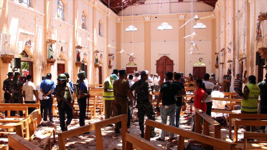 Agentes de seguridad caminan por la iglesia San Sebastián, destruida en parte por una explosión, Negombo, Sri Lanka, 21 de abril de 2019. (Foto: AFP)