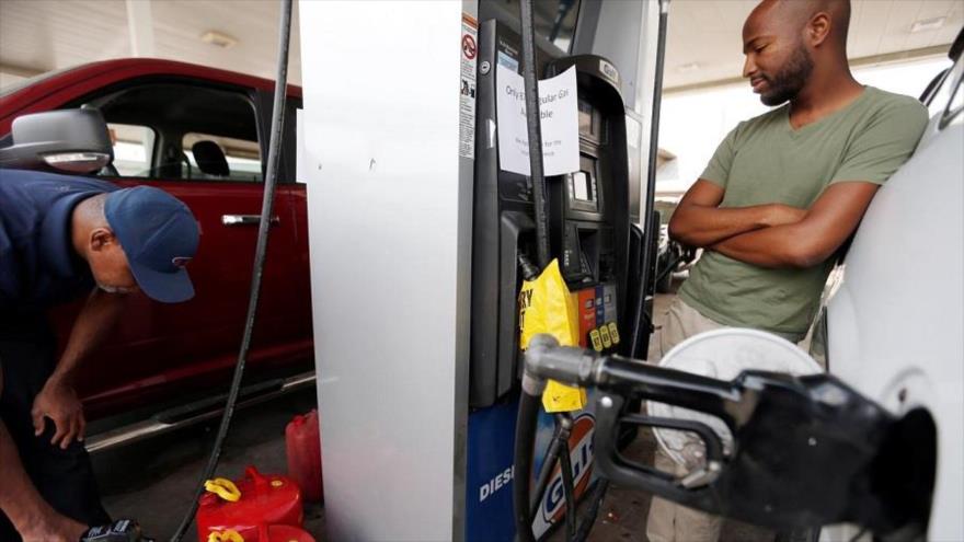 Un consumidor estadounidense espera mientras carga el tanque de gasolina de su vehículo en una estación de repostaje en EE.UU.
