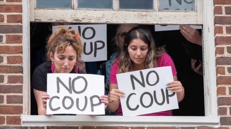 Activistas de la organización Code Pink muestran carteles desde una de las ventanas de la Embajada de Venezuela en EE.UU., 9 de mayo de 2019. (Foto: codepink.org)
