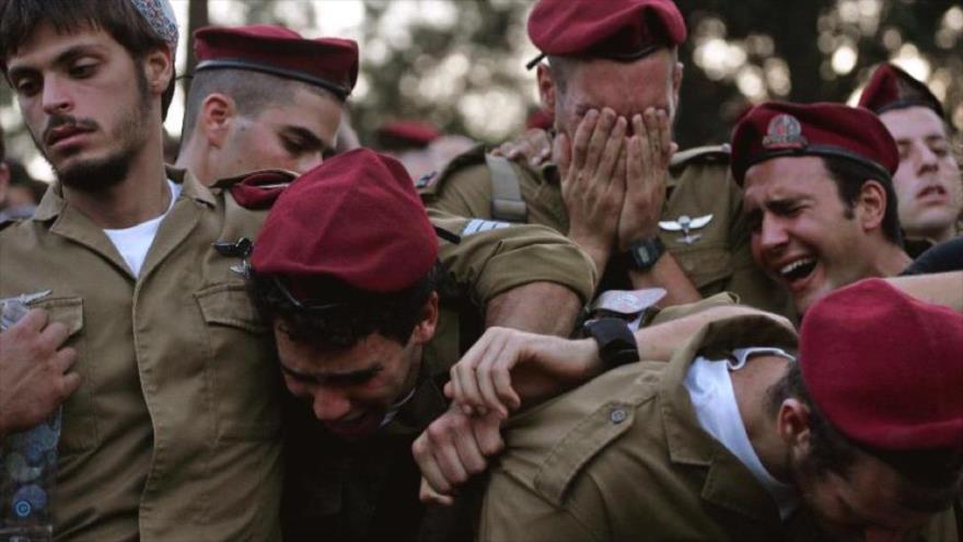 Soldados israelíes lloran durante el funeral de su amigo en un cementerio en los territorios ocupados palestinos.