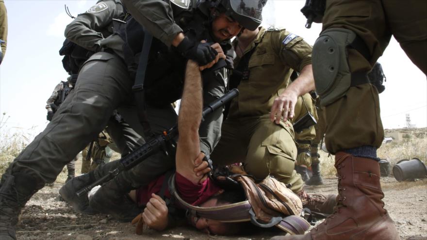 Fuerzas israelíes detienen a un activista palestino cerca de la ciudad de Yatta en la Cisjordania ocupada, 3 de mayo de 2019. (Foto: AFP)