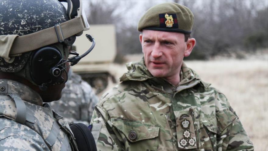 Christopher Ghika, comandante adjunto británico de la llamada coalición anti-EIIL, habla con un soldado de EE.UU., 24 de febrero de 2014.