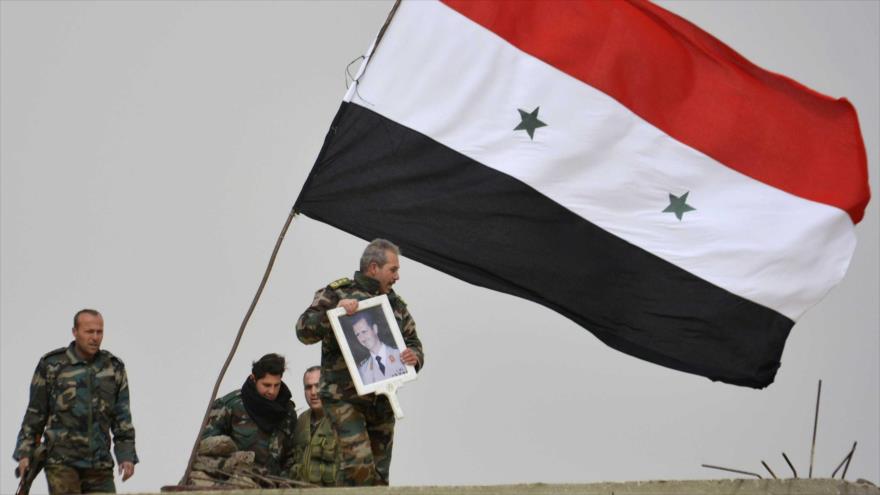 Los militares sirios portan la imagen del presidente del país, Bashar al-Asad.