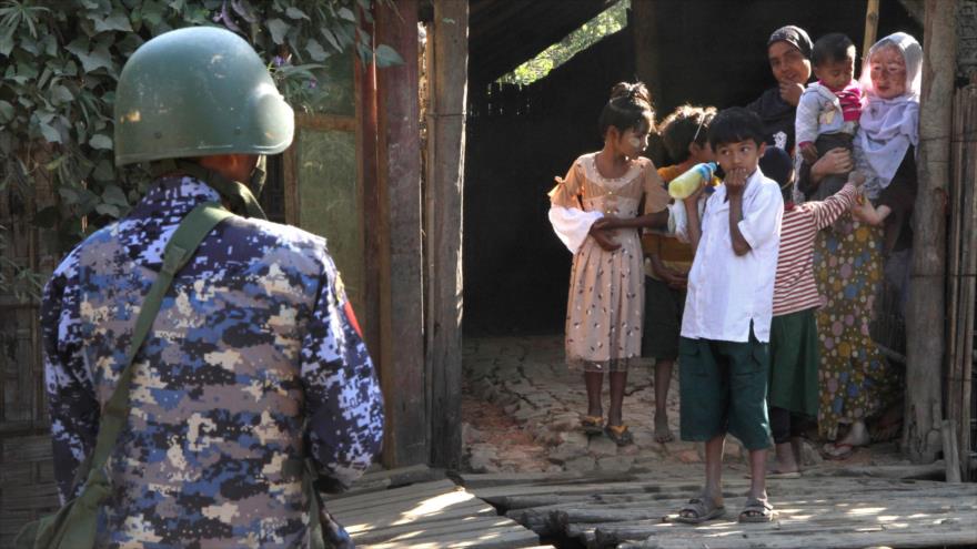 Un policía de la guardia de fronteras de Myanmar cerca de una familia musulmana rohingya en el estado de Rajine (oeste), 25 de enero de 2019. (Foto: AFP)