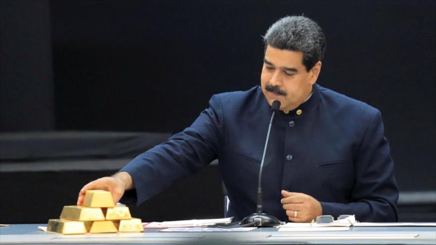 El presidente venezolano, Nicolás Maduro, habla en Caracas, la capital, mientras toca una pila de lingotes de oro, 22 de marzo de 2018.