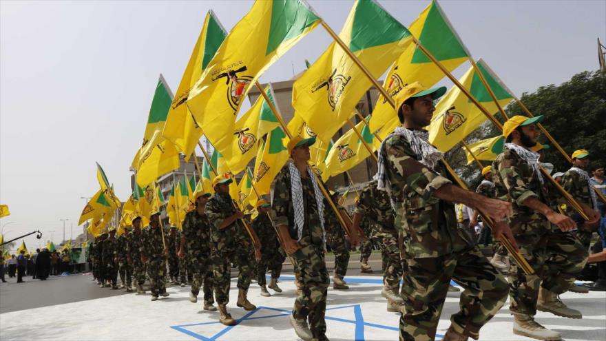 Combatientes del Movimiento de Resistencia Islámica de Irak (Kataib Hezbolá) pisotean la bandera israelí durante un desfile militar en Bagdad.