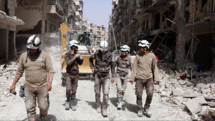 Los llamados cascos blancos caminan en una calle de Idlib, noroeste de Siria.