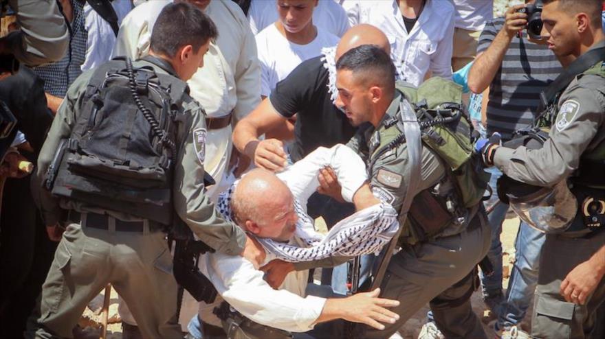 Soldados israelíes golpean a un anciano palestino en los territorios ocupados palestinos.