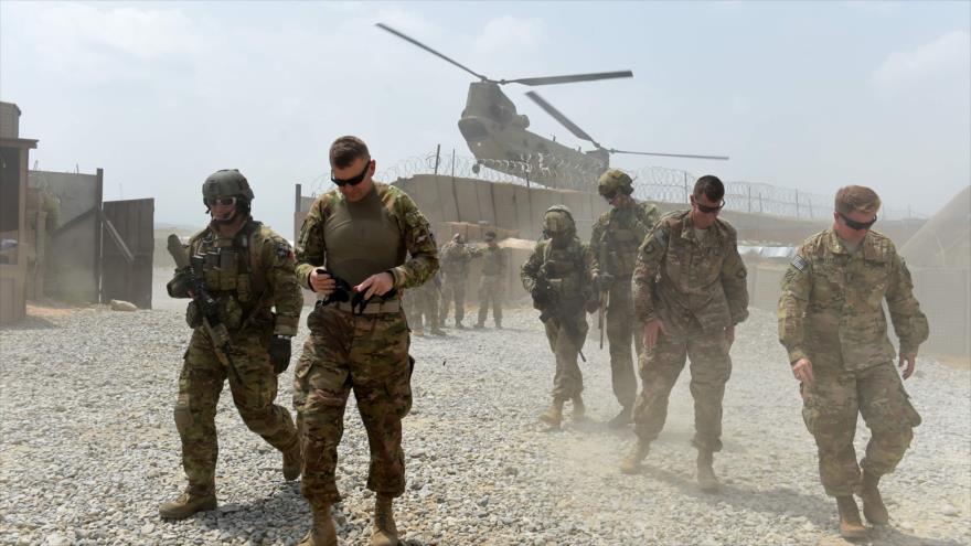 Soldados del Ejército de EE.UU. caminan mientras un helicóptero de la OTAN sobrevuela una base en Nangarhar (Afganistán), agosto de 2015. (Foto: AFP)