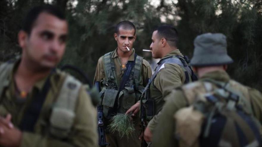 Soldados del régimen de Israel fumando cigarrillos.