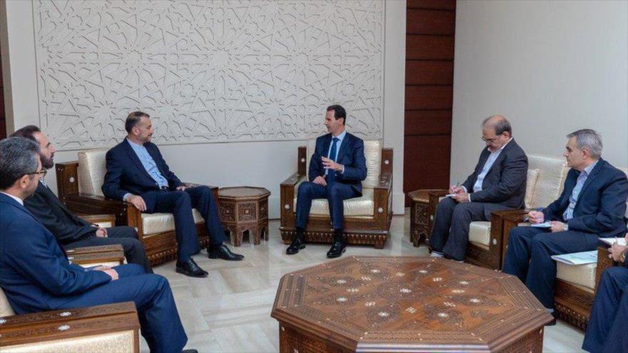 El presidente sirio, Bashar al-Asad (dcha.) se reúne con el el director general para Asuntos Internacionales del Parlamento iraní, Hosein Amir Abdolahian, 15 de julio de 2019.