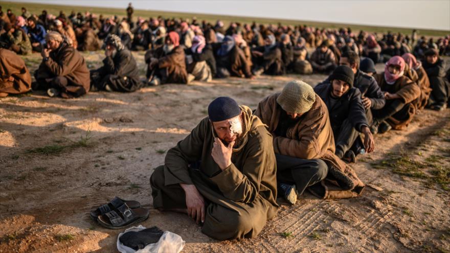 Hombres sospechosos de ser terroristas de EIIL (Daesh, en árabe) esperan ser registrados por los kurdos sirios en Deir Ezzor, 22 de febrero de 2019. (Foto: AFP)