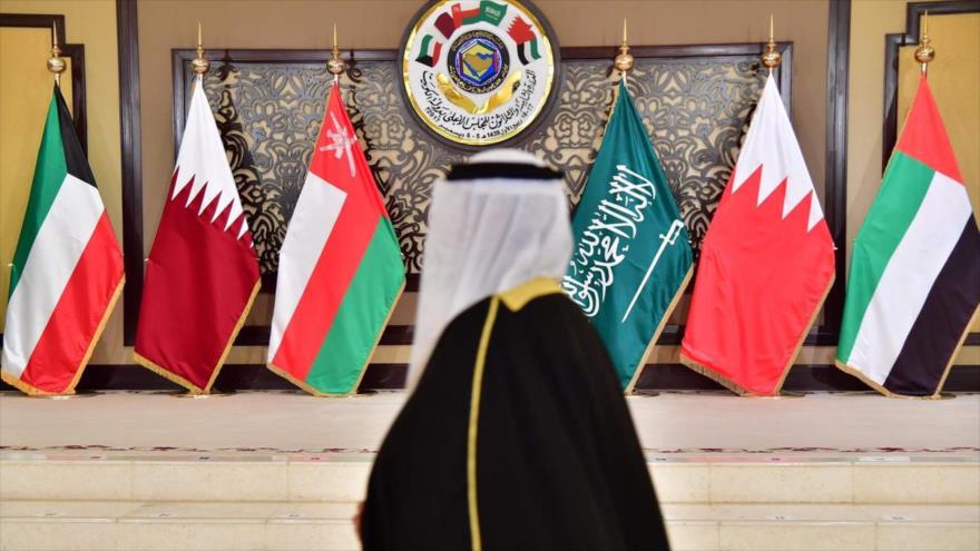 Un hombre pasa junto a las banderas de los países que asistieron a la cumbre del Consejo de Cooperación del Golfo (CCG) en el palacio Bayan en la ciudad de Kuwait, 5 de diciembre de 2017.