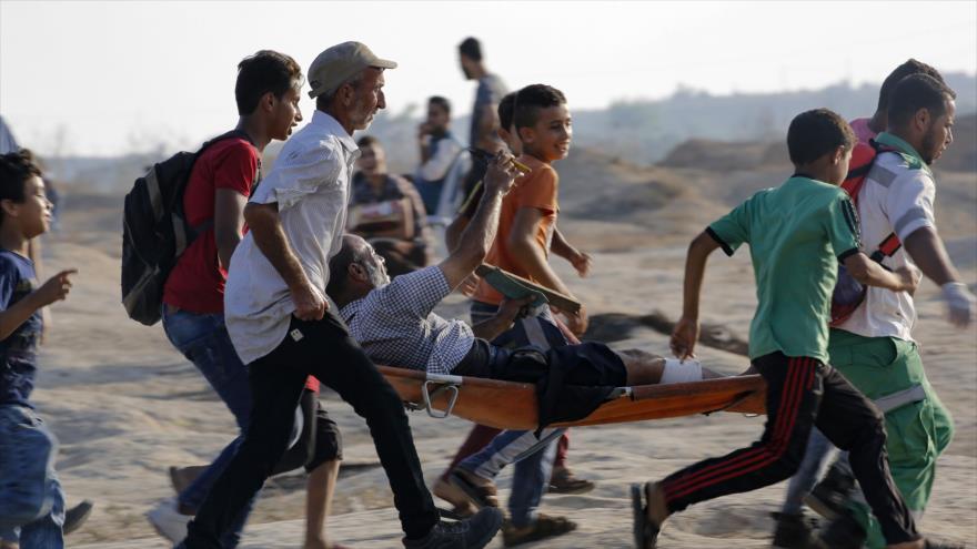 Llevan a un palestino herido durante las marchas en la Franja de Gaza, 2 de agosto de 2019. (Foto: AFP)