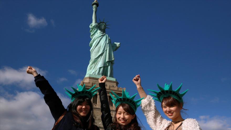 Turistas japonesas en frente de la Estatua de la Libertad de Nueva York, Estados Unidos.