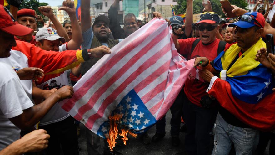 Venezolanos queman una bandera de EE.UU. durante una protesta contra las sanciones estadounidenses, Caracas, 10 de agosto de 2019. (Foto: AFP)