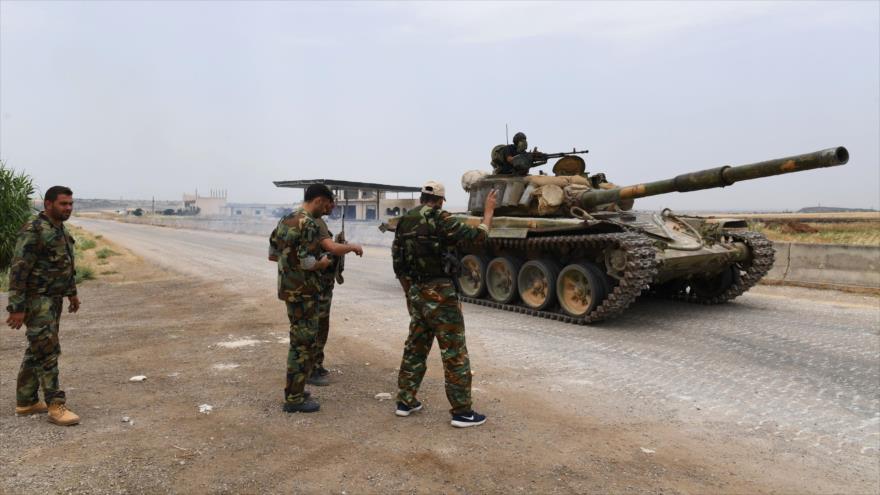 Soldados sirios cerca de un tanque en una carretera en la provincia de Hama durante enfrentamientos con los terroristas, 8 de junio de 2019. (Foto: AFP)