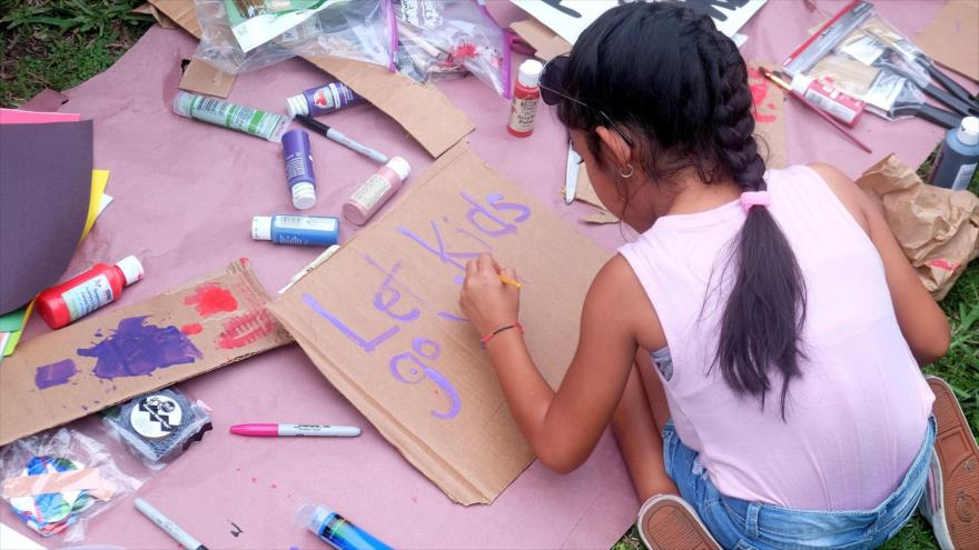  Una niña pinta un letrero durante una manifestación de protesta frente al Refugio Temporal Homestead en Florida, junio de 2019.