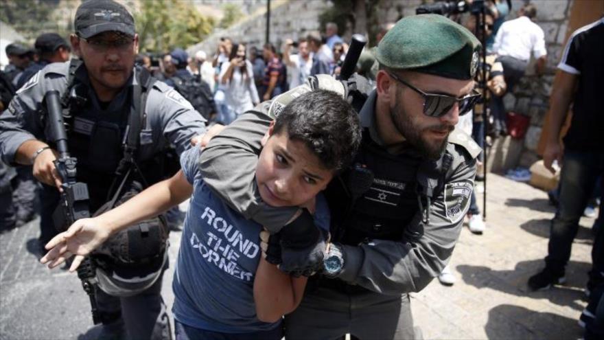 Fuerzas israelíes detienen a un menor palestino cerca de una entrada al complejo de la Mezquita Al-Aqsa, en Al-Quds (Jerusalén), 17 de julio de 2019. 