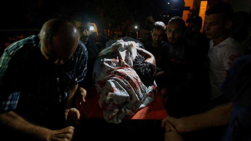 Los palestinos llevan el cuerpo de una de las dos víctimas de un ataque en el oeste de la Franja de Gaza, 27 de agosto de 2019. (Foto: AFP)