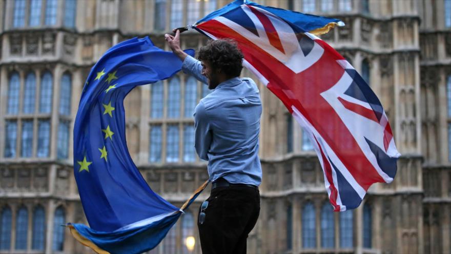 Un hombre ondea una bandera de la UE y una del Reino Unido cerca del Parlamento británico, 28 de junio de 2018. (Foto: AFP)