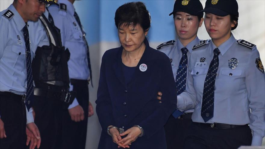La cesada presidenta de Corea del Sur Park Geun-hye (izda.), acompañada por una policía, llega a un tribunal en Seúl, capital, 25 de agosto de 2017.
