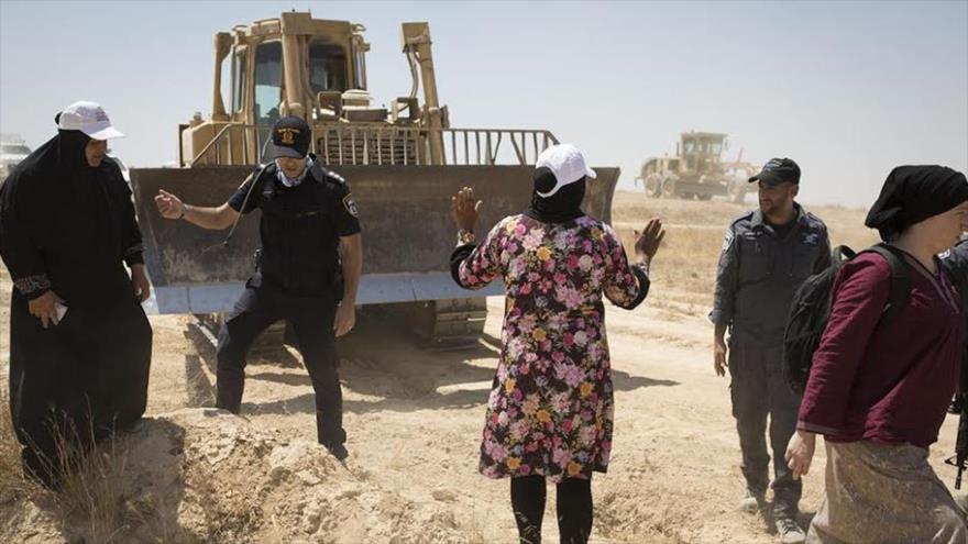 Una mujer beduina intenta bloquear una excavadora de las fuerzas israelíes en la aldea palestina de Al-Araqib, 24 de julio de 2016. 