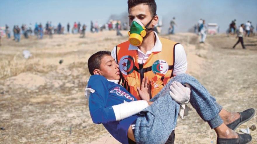 Un médico se lleva a un niño palestino herido en protestas en la Franja de Gaza por fuerzas israelíes.