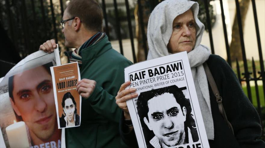 Manifestantes con carteles con la imagen del bloguero saudí Raif Badawi frente a la embajada de Arabia Saudí en Londres, el Reino Unido.