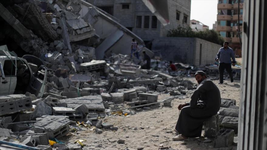 Un palestino se sienta en un edificio destruido por los ataques aéreos israelíes en Gaza.