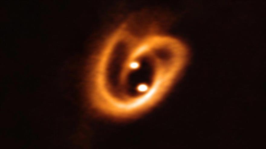  El telescopio del desierto de Atacama (Chile) capta dos estrellas bebés que forman un ‘pretzel’ cósmico.