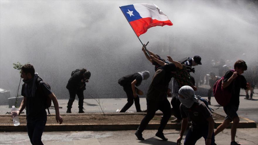 Los manifestantes se enfrentan con la policía antidisturbios en una protesta en Santiago, Chile, 21 de octubre de 2019 (Foto: AFP)