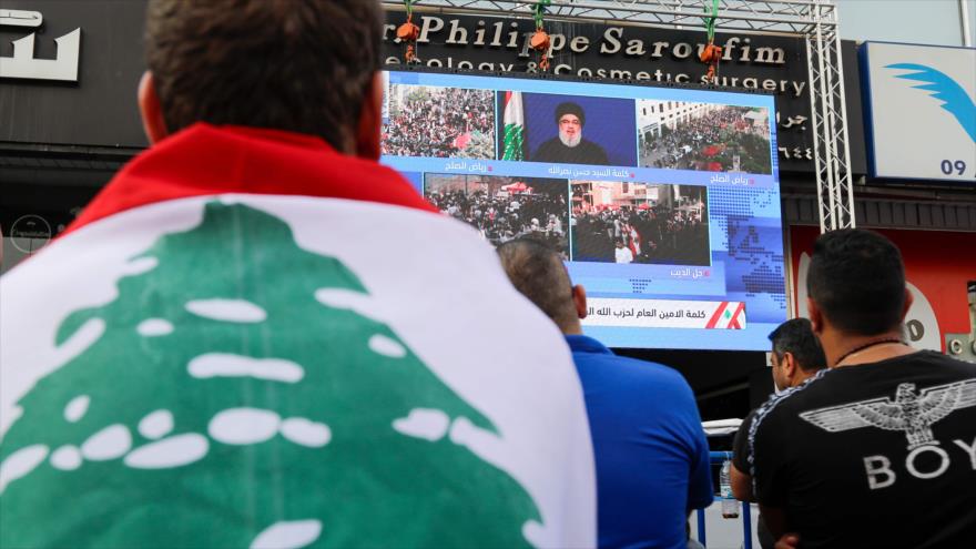 Una pantalla en una calle de Beirut difunde un discurso del líder de Hezbolá, Seyed Hasan Nasralá, por protestas en El Líbano, 25 de octubre de 2019.