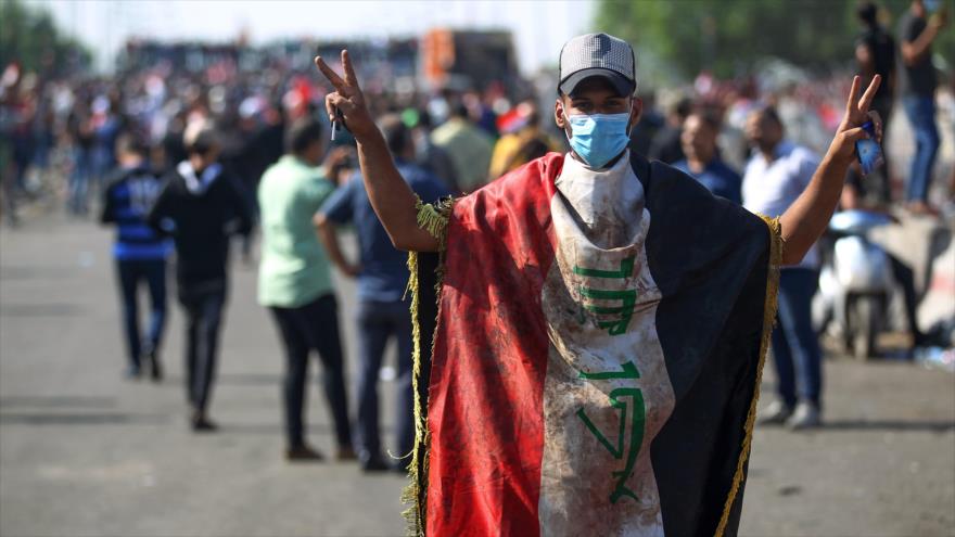 Un manifestante iraquí, envuelto en una bandera nacional, en la ciudad de Bagdad, capital de Irak, 26 de octubre de 2019. (Fuente: AFP). 