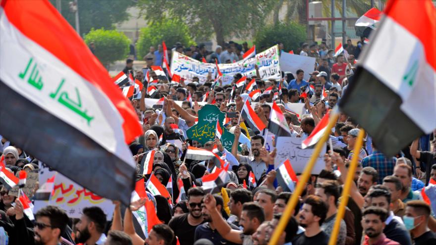 Manifestantes iraquíes izan la bandera nacional en una protesta en la ciudad central de Diwaniyah, 31 de octubre de 2019. (Foto: AFP)