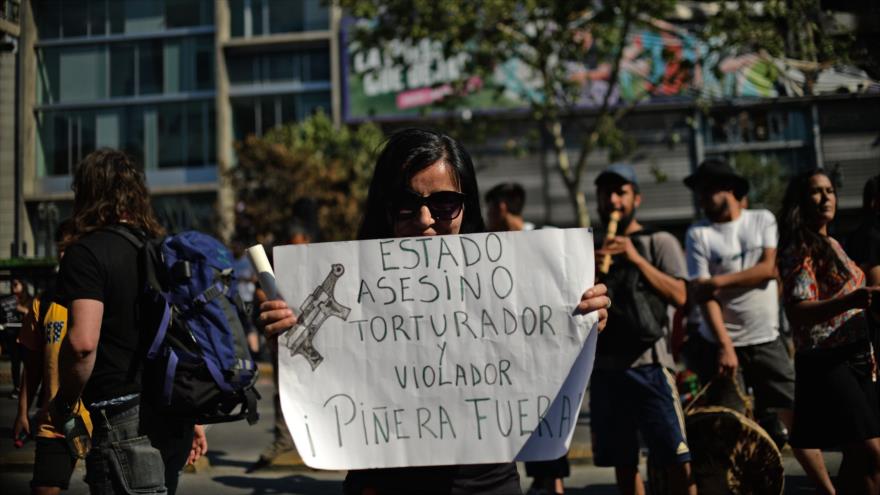 Una mujer sostiene un cartel durante una protesta contra el Gobierno del presidente chileno Sebastián Pinera, en Santiago, 3 de noviembre de 2019. (Foto: AFP)