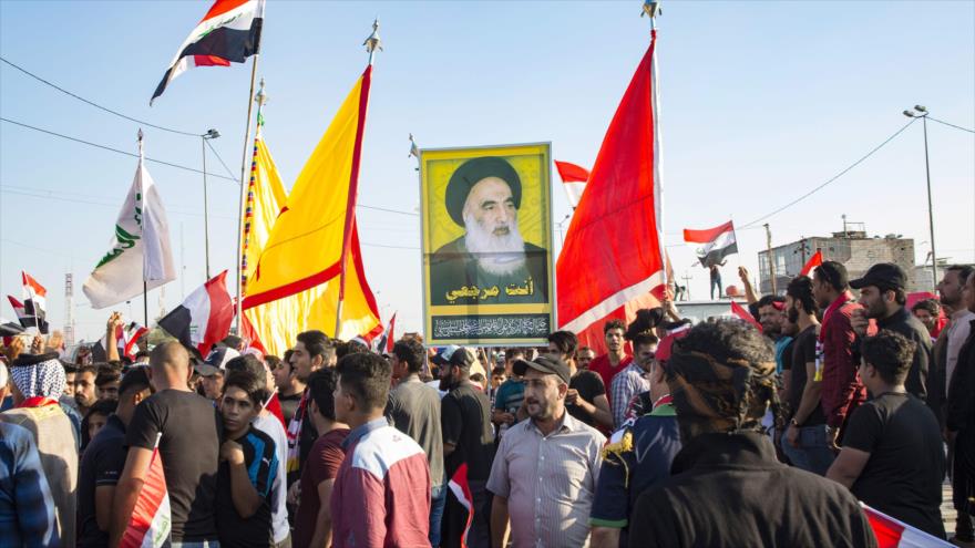 Manifestantes iraquíes llevan una imagen del máximo clérigo chií de Irak, el ayatolá Seyed Ali Sistani, en Basora (sur), 1 de noviembre de 2019. (Foto: AFP)