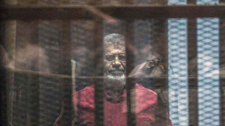 El fallecido expresidente de Egipto Muhamad Mursi en una sesión del juicio en su contra en El Cairo, capital egipcia, 23 de abril de 2016.