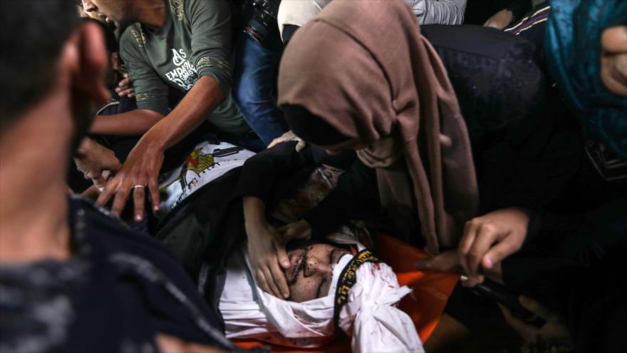 Familiares de un palestino muerto en ataques israelíes se despiden de él antes de su funeral en la Franja de Gaza, 12 de noviembre de 2019. (Foto: AFP)