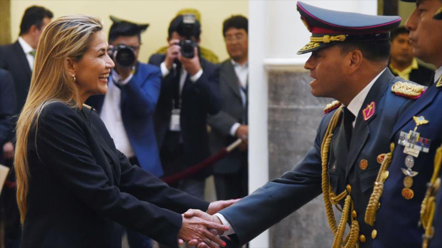 La autoproclamada presidenta interina de Bolivia, Jeanine Áñez, le estrecha la mano al nuevo comandante en jefe de las Fuerzas Armadas del país, La Paz, 13 de noviembre de 2019. (Foto: AFP)