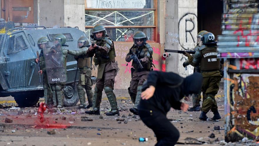 Policía antidisturbios apunta a un manifestante en una protesta contra el Gobierno en Santiago, capital de Chile, 14 de noviembre de 2019. (Foto: AFP)