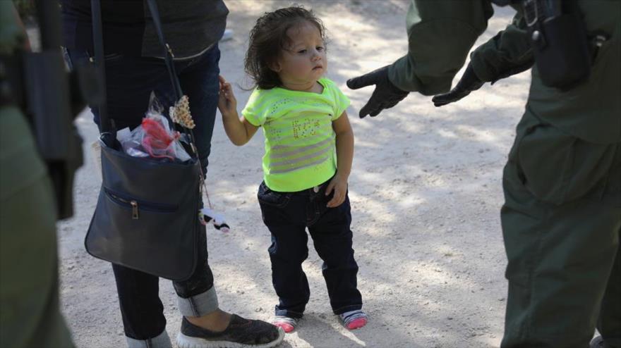 Una guardia fronteriza estadounidense intenta separa una niña de su madre.