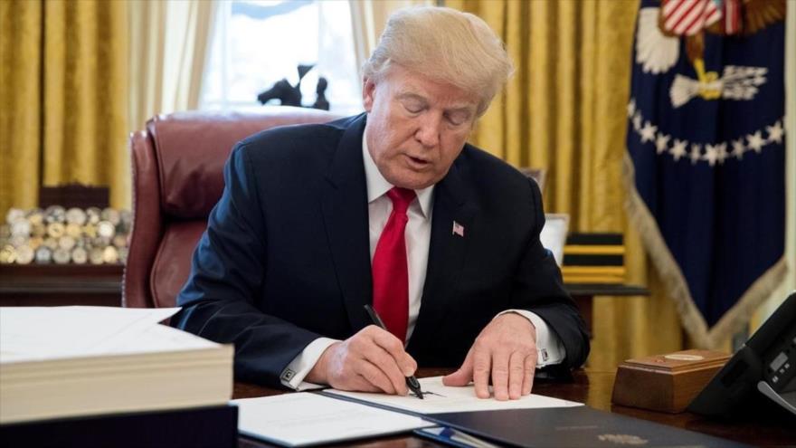 El presidente de EE.UU., Donald Trump, firma una ley en el Despacho Oval de la Casa Blanca.