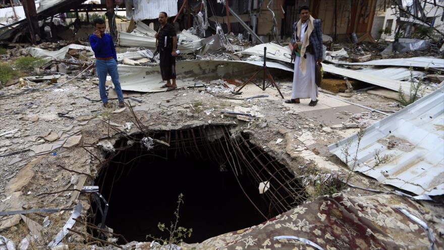 Yemeníes observan el lugar del impacto de una bomba lanzada por los aviones de Arabia Saudí en la capital de Yemen, Saná, el 8 de octubre de 2019. (Foto: AFP)