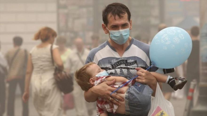 Unas personas usan máscaras para protegerse de la contamination del aire.
