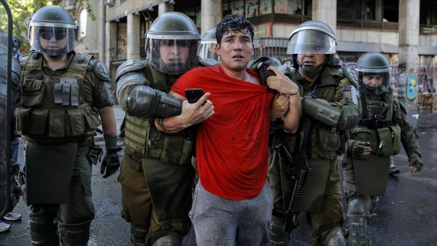 Policía antidisturbios arresta a un manifestante durante una protesta en Santiago, capital de Chile, 4 de diciembre de 2019. (Foto: AFP)